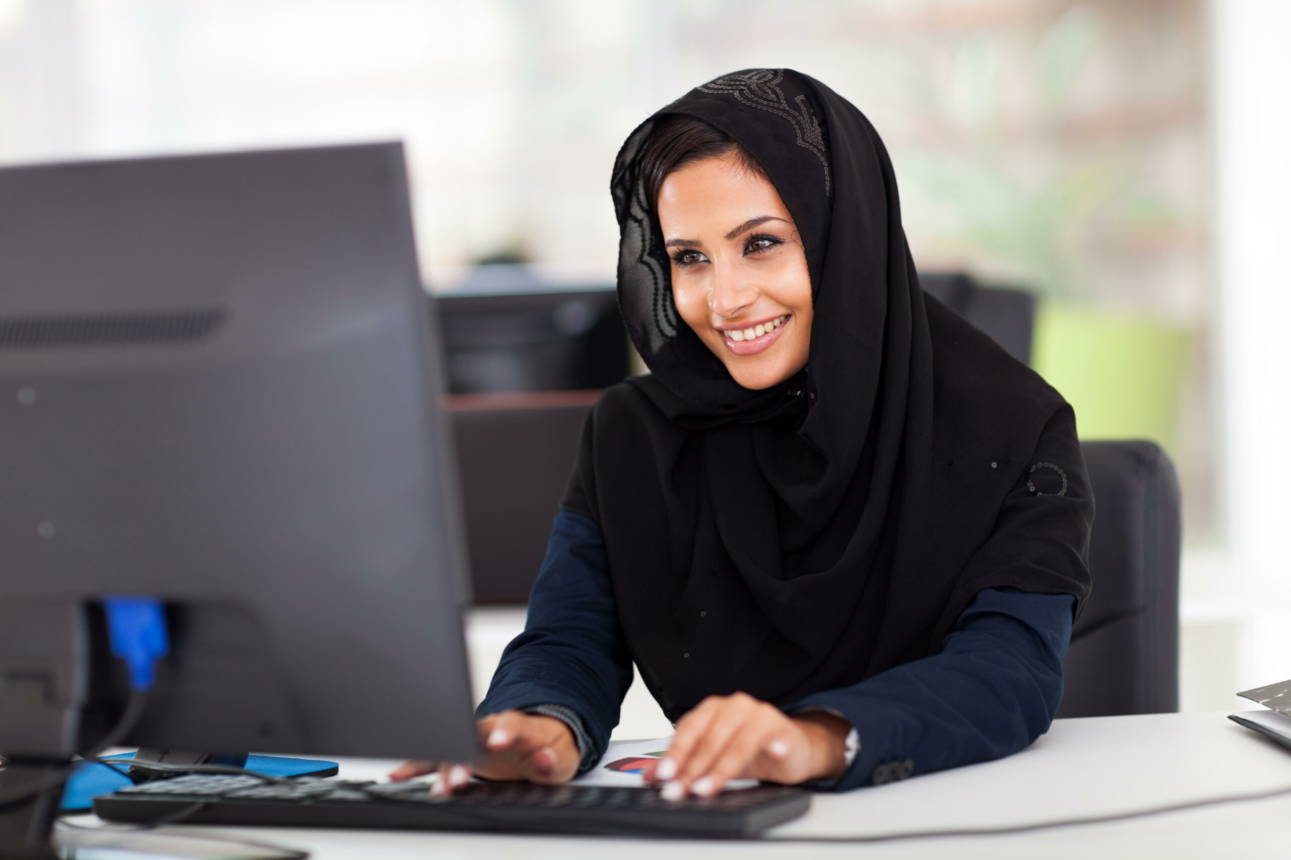 attractive female Arabic corporate worker working on computer