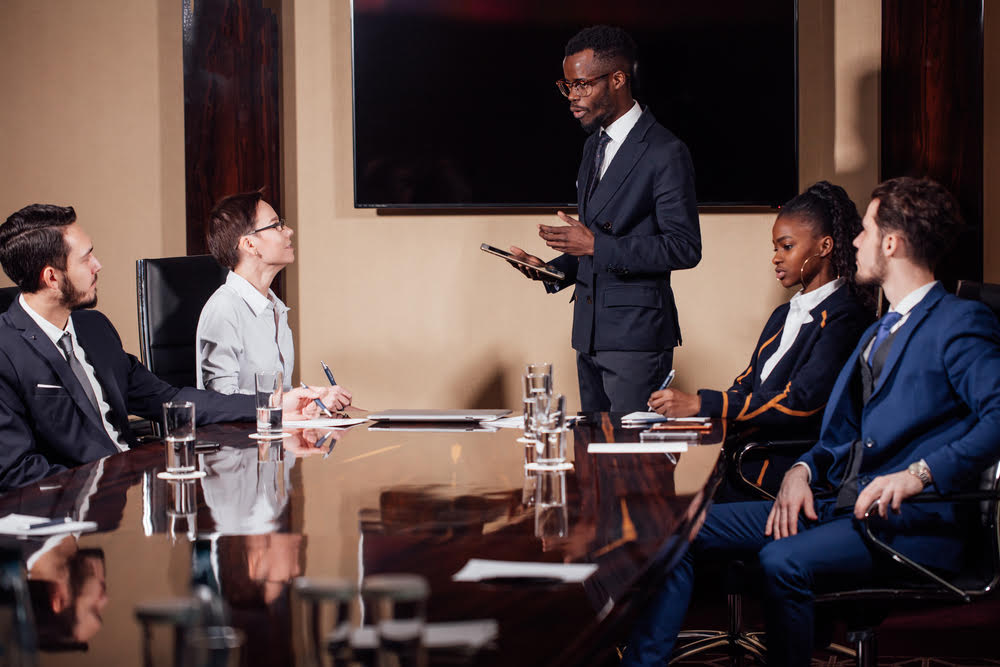 African American business man giving a presentation to associates